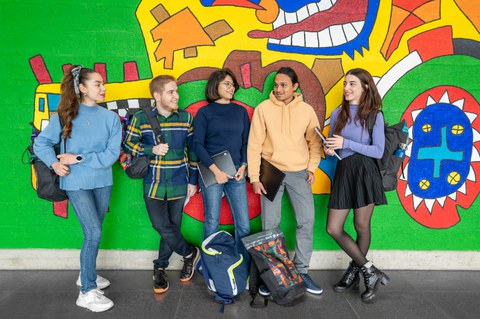 Gruppe von Studenten an der Elbe. Sie spielen Volleyball und sitzen plaudernd auf der Wiese