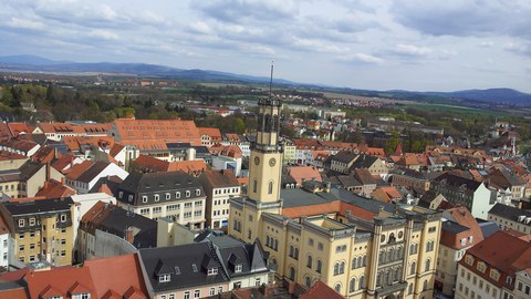 Foto mit Blick auf die Stadt Zittau von einem Kirchturm aus. Im Mittelpunkt des Bildes ist das Zittauer Rathaus zu sehen.