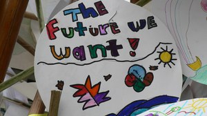 Foto mit einem kreisrunden weißen Bild, das bunt bemalt ist. In der oberen Hälfte steht in verschieden farbigen Buchstaben “The future we want”-