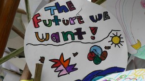 Foto mit einem kreisrunden weißen Bild, das bunt bemalt ist. In der oberen Hälfte steht in verschieden farbigen Buchstaben “The future we want”-