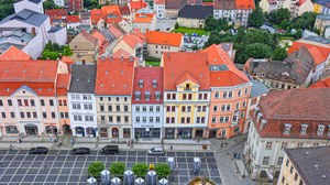 Blick von einem Turm auf das Hauptgebäude des IHI Zittau sowie den Marktplatz und die Nachbargebäude. Es ist ein barockes Gebäudeensemble.