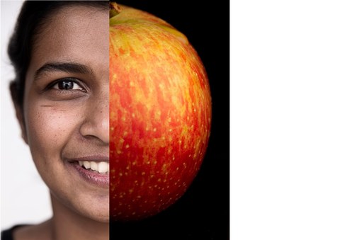 Gesicht einer Studierenden, andere Hälfte Apfel
