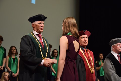 Feierliche Graduierungszeremonie für das Double Degree an der TU Liberec. Der Dekan der wirtschaftswissenschaftlichen Fakultät, Herr Professor Kocourek, gratuliert einer Studierenden.