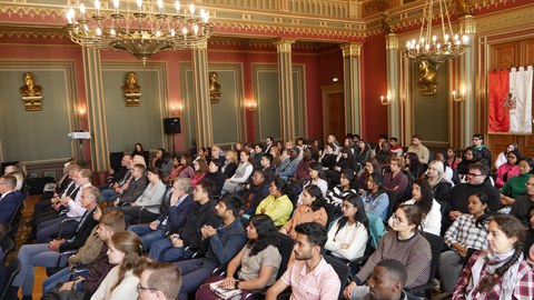 Feierliche Begrüßung des Matrikels 2024 am IHI Zittau im prachtvollen Bürgersaal des Zittauer Rathauses. Zu sehen sind voll besetzte Stuhlreihen mit internationalen Studierenden während der Veranstaltung.