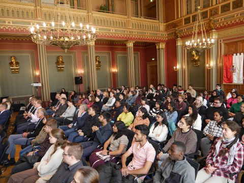 Feierliche Begrüßung des Matrikels 2024 am IHI Zittau im prachtvollen Bürgersaal des Zittauer Rathauses. Zu sehen sind voll besetzte Stuhlreihen mit internationalen Studierenden während der Veranstaltung.