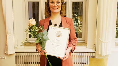 Kathleen Klement mit der Lohrmann-Medaille der TU Dresden und einer Rose.