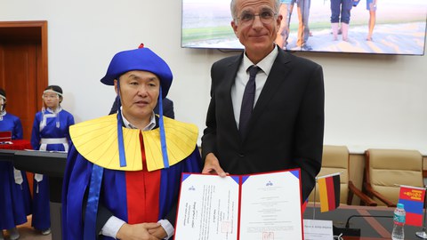 Der Rektor der Mongolischen Nationaluniversität und Prof. Karsten Wesche mit der Ehrendoktor-Urkunde