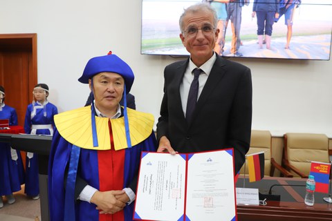 Der Rektor der Mongolischen Nationaluniversität und Prof. Karsten Wesche mit der Ehrendoktor-Urkunde