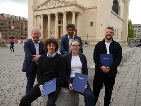 Die Preisträger:innen des Otto-Borst-Preises 2023 sowie Mitglieder der Jury sind vor einer Kirche im Hintergrund zu sehen und zeigen ihre Preisurkunden.