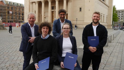 Die Preisträger:innen des Otto-Borst-Preises 2023 sowie Mitglieder der Jury sind vor einer Kirche im Hintergrund zu sehen und zeigen ihre Preisurkunden.