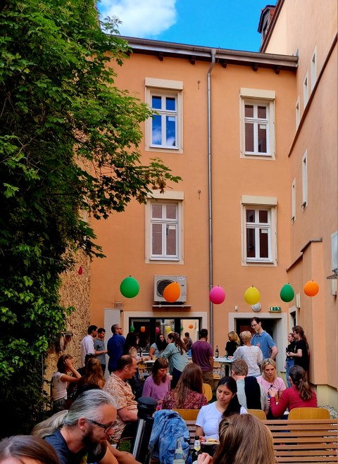 Mitarbeitende und Studierende feiern zusammen im Innenhof des IHI Zittau
