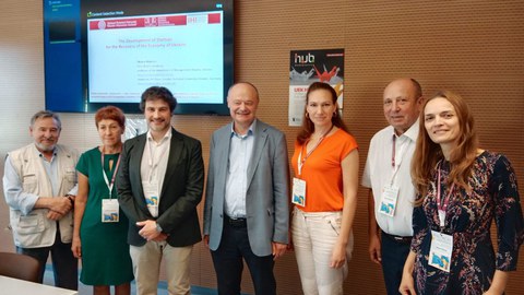Prof. Oksana Makovoz und andere Teilnehmende des Seminars stehen im Seminarraum. Im Hintergrund ist eine Powerpoint-Präsentation zu sehen.
