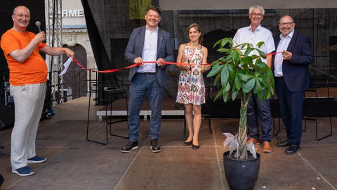 Der Zittauer Oberbürgermeister Thomas Zenker, die ZLSB-Regionalstellenkoordinatorin Dr. Elisa Rößler, IHI-Direktor Prof. Thorsten Claus sowie ZLSB-Direktor Prof. Axel Gehrmann schneiden auf der Hauptbühne des Zittauer Stadtfestes ein rotes Band durch, um die Eröffnung des Regionalbüros zu symbolisieren.
