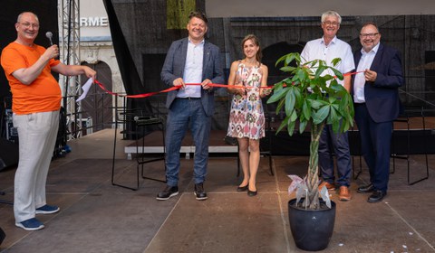 Der Zittauer Oberbürgermeister Thomas Zenker, die ZLSB-Regionalstellenkoordinatorin Dr. Elisa Rößler, IHI-Direktor Prof. Thorsten Claus sowie ZLSB-Direktor Prof. Axel Gehrmann schneiden auf der Hauptbühne des Zittauer Stadtfestes ein rotes Band durch, um die Eröffnung des Regionalbüros zu symbolisieren.