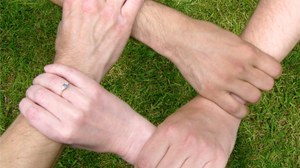 Foto mit 4 ineinander fassenden Händen