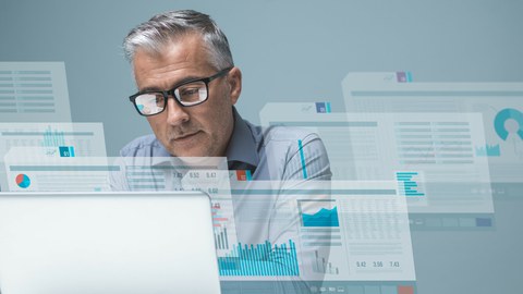 Scientist in front of laptop with several visible screen content versions