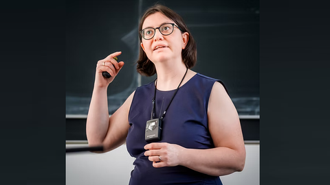 Frau Prof. Caroline Murawski gestikuliert beim Beantworten einer Fragestellung vor der Tafel.