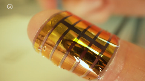 Ein Puls-Oximeter auf Basis von organischen Halbleitern mit flexiblen Substrat. Der Sensor glänzt goldig und ist wie ein Pflaster um den Finger gewickelt.
