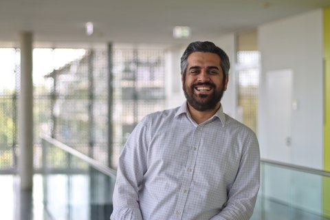 Siddhartha Saggar wears a shirt with a square pattern and smiles to the camera.
