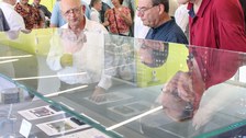 Besucher des Kolloquiums schauen sich Ausstellungsstücke im Schaukasten des Werner-Hartmann-Baus an.