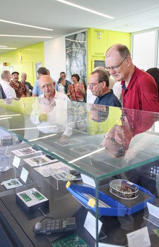Besucher des Kolloquiums schauen sich Ausstellungsstücke im Schaukasten des Werner-Hartmann-Baus an.