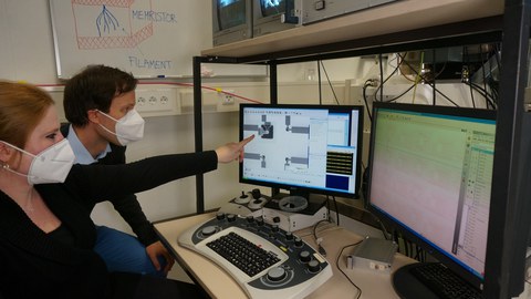 Melanie Herzig (NaMLab) und Christian Bruchatz (MemrisTec Koordination) begutachten eine ferromagnetische Memristor-Schaltung