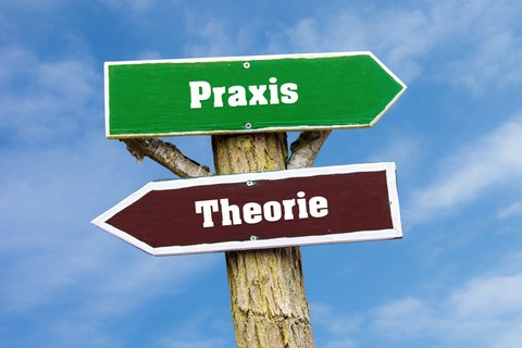 2 Wegweisschilder, die Schrift lautet "Theorie" und "Praxis"