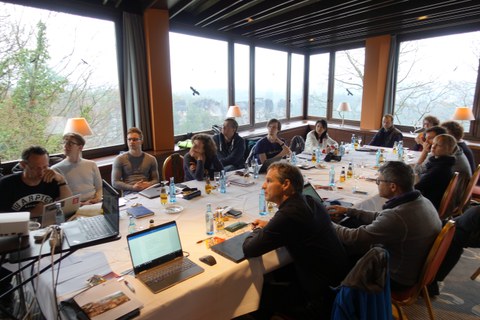 Mehrere Personen sitzen an einem Konferenztisch und diskutieren.