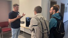 Mitarbeiter erklärt Besuchern den 3 D Druckern