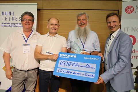 Foto der Übergabe des Roland-Wagner-Preis an Herrn Weber. Zu sehen sind v.l.nr. Klaus Höckner (Hilfsgemeinschaft der Blinden und Sehschwachen Österreichs), Klaus Miesenberg, Gerhard Weber und Dr. Ronald Bieber.