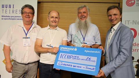 Photo of the presentation of the Roland Wagner Prize to Mr. Weber. Pictured, from left to right, are Klaus Höckner (Austrian Association for the Blind and Visually Impaired), Klaus Miesenberg, Gerhard Weber, and Dr. Ronald Bieber.