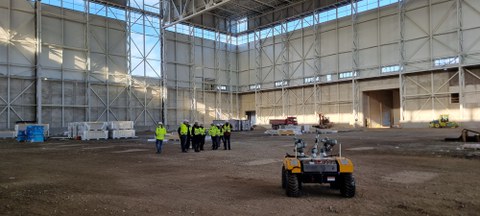Testhalle des SLM mit Besuchergruppe und Wartog im Vordergrund