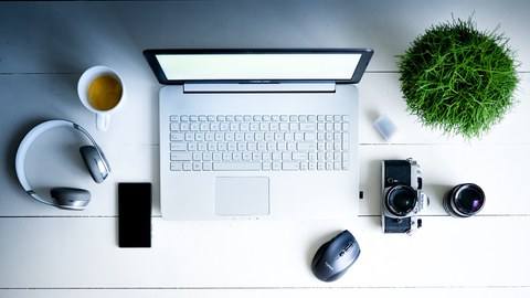 Laptop, Kopfhörer, Kaffe, Fotoapparat, Linsen auf Tisch