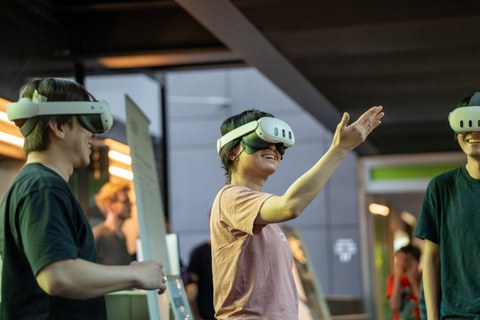Three people using Multi-User Mixed Reality together.