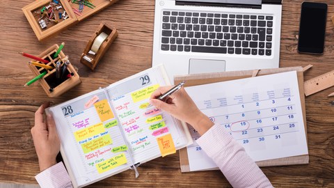 Schreibtisch mit Kalender und Laptop