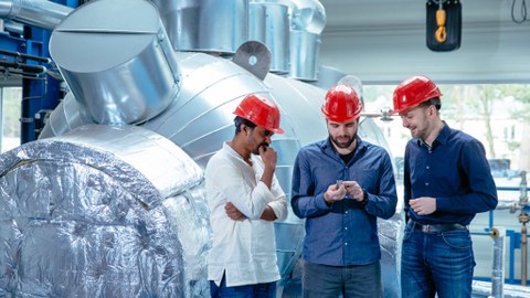Foto der thermohydraulischen Versuchsanlage TOPFLOW am HZDR mit 3 Mitarbeitern