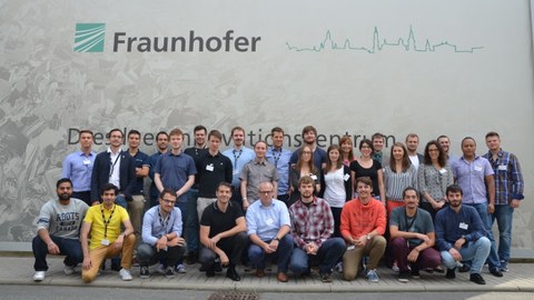 Group photo of the thirty one participants of the Summer School in front of the Fraunhofer IWS logo