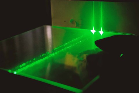 Zwei grüne Laserstrahlen werden durch ein durchsichtiges Polymer geleitet