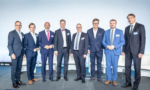 Die Teilnehmer der Podiumsdiskussion nebeneinander, schauen in die Kamera.