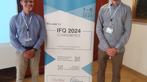 Daniel Bernhardt und Matteo Giesen vor dem Plakat der IFQ 2024.