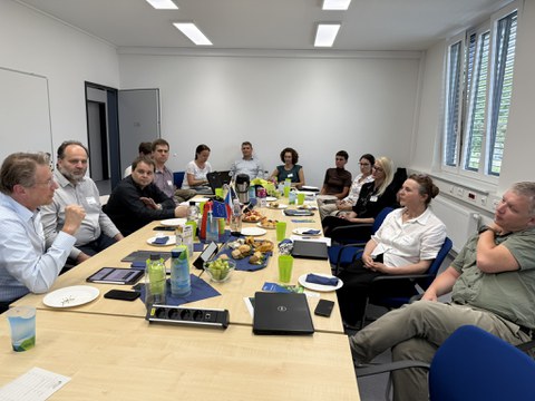 Während der Besprechung, ein Tisch in der Mitte, Menschen zu beiden Seiten.
