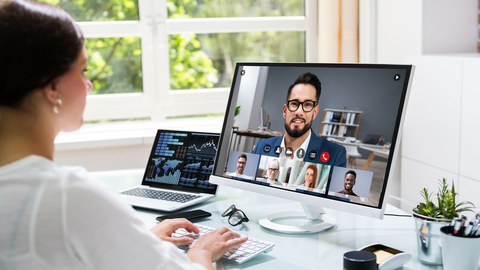 Foto einer Person an ihrem Schreibtisch, die mit 5 Kollegen ein Online-Meeting hält.