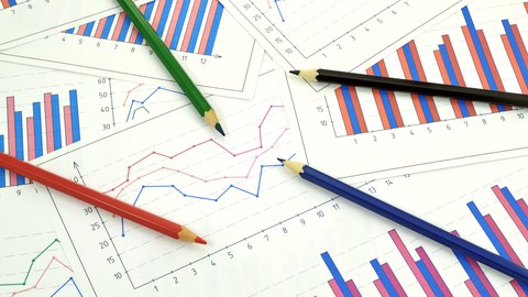 Das Foto zeigt viele Diagramme. Diese liegen kreuz und quer übereinander. Auf den Diagrammen liegen vier Bundstifte in unterschiedlichen Farben.