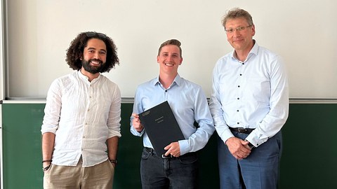 3 Personen strahlen nach der erfolgreichen Verteidigung in die Kamera.