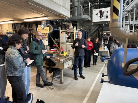 Bild zeigt Dr.-Ing. Simon Unz während der Führung durch das ZET, umgeben von den BesucherInnen.