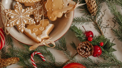 Tisch mit Tannenzweigen, Plätzchen und weihnachtlichen Lebkuchen