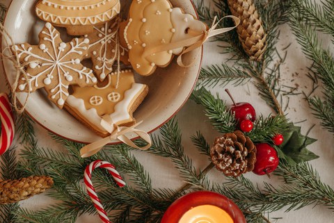 Tisch mit Tannenzweigen, Plätzchen und weihnachtlichen Lebkuchen