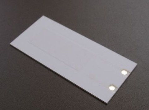Photograph of a ceramic multilayer system based on LTCC technology, which includes piezoceramic functional parts.