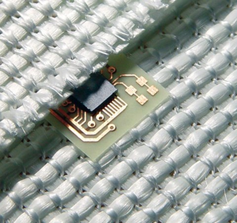 Das Bild zeigt einen in ein Gewebe eingebetteten mikroelektronischen Schaltkreis