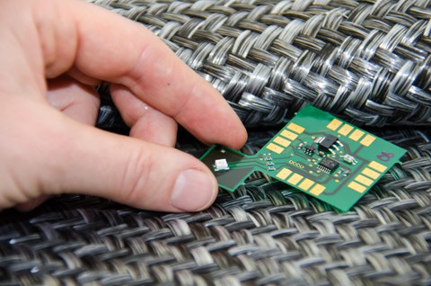 Detailaufnahme eines Gewebes in das ein Chip eingelegt wird.